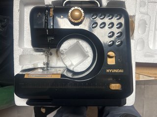 Máquina de coser negra con detalles dorados