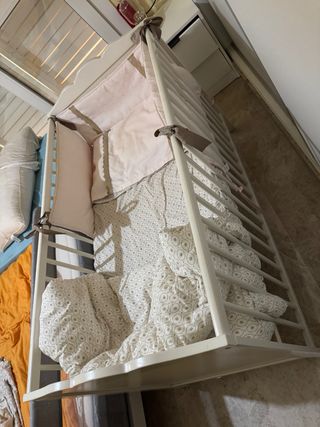 Cuna blanca con textiles.