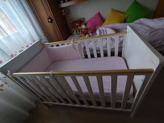 Cuna de bebé blanca con detalles dorados