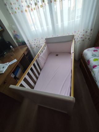 Cuna de bebé blanca con detalles dorados