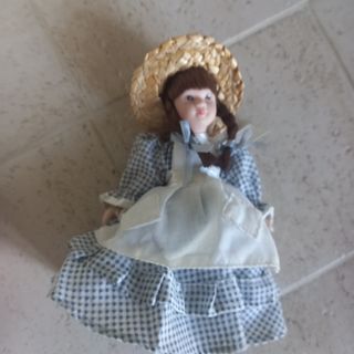 Bambola di porcellana con cappello di paglia