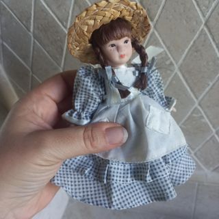 Bambola di porcellana con cappello di paglia