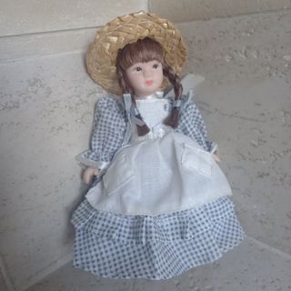 Bambola di porcellana con cappello di paglia