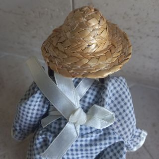 Bambola di porcellana con cappello di paglia