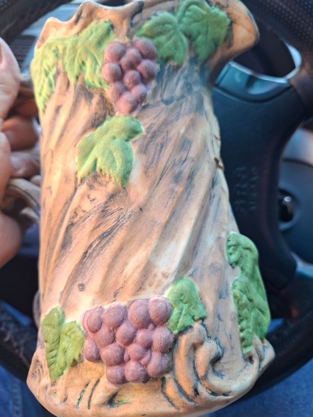 Jarra de vino de biscuit con uvas