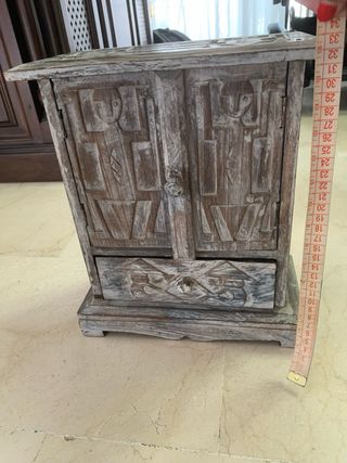 Mueble de madera tallado con puertas y cajón