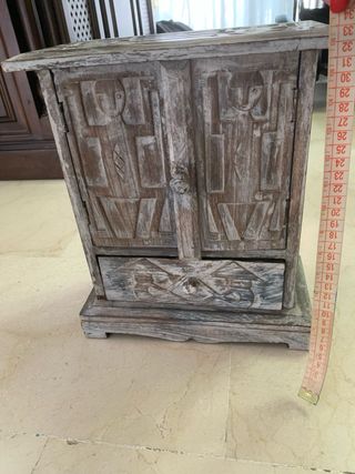 Mueble de madera tallado con puertas y cajón