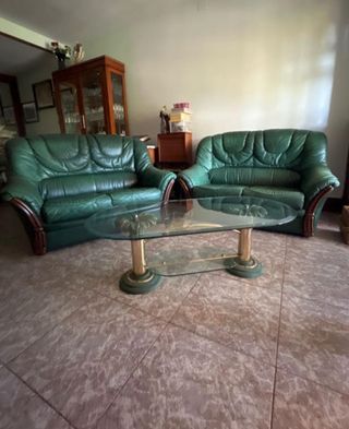 Sofá de piel verde y mesa de cristal