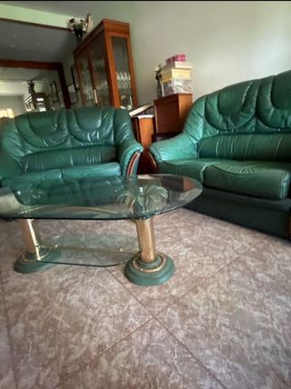Sofá de piel verde y mesa de cristal