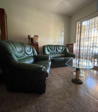 Sofá de piel verde y mesa de cristal