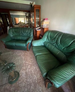 Sofá de piel verde y mesa de cristal