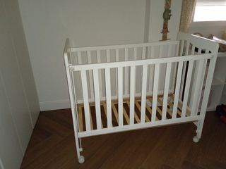 Cuna roble Micuna 120x60 con barrera móvil ruedas