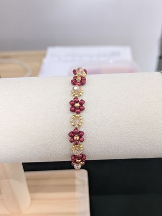 Pulsera artesanal con cuentas doradas y rojas