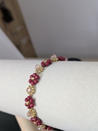 Pulsera artesanal con cuentas doradas y rojas