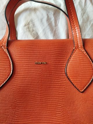 Bolso de mano naranja con textura