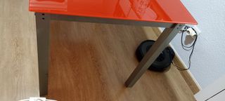 Mesa de cristal roja con patas metálicas