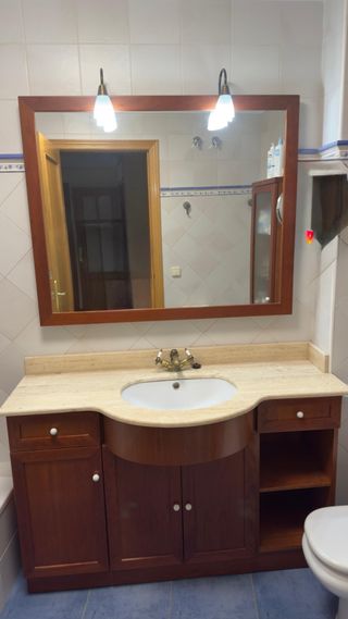 Mueble de baño de mármol con espejo de madera.