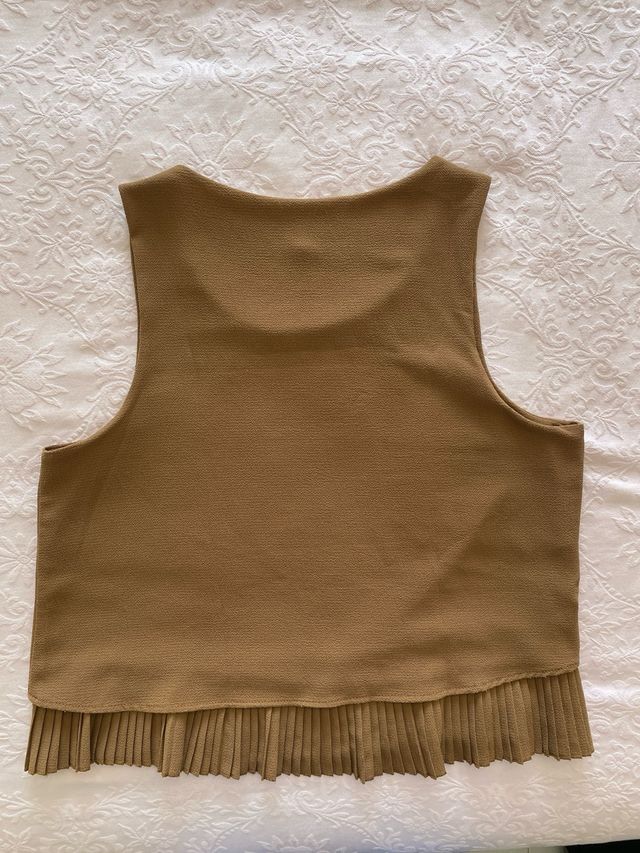 Top smanicato con pieghe