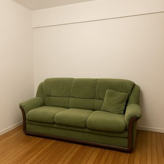 Sofá verde de tela con cojín