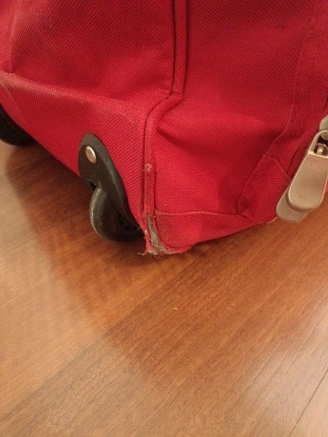 Maleta de viaje roja con ruedas y asa
