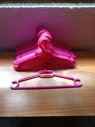 Perchas pequeñas de plástico rosa y rojo