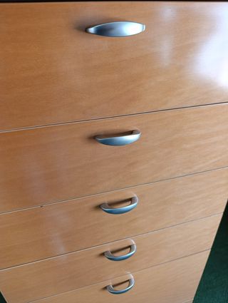Cómoda de madera naranja con tiradores plateados