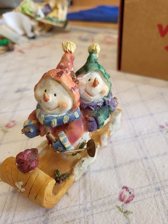 Figuritas de muñecos de nieve en trineo