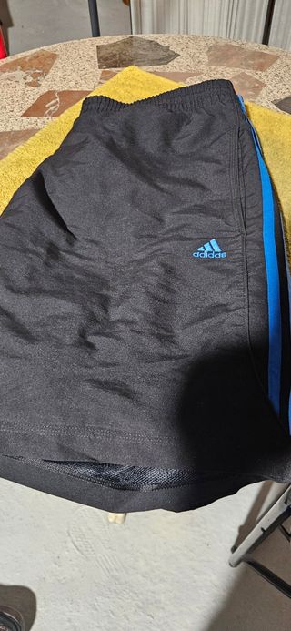 Dos pantalones deportivos Adidas negro y rojo.