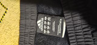 Dos pantalones deportivos Adidas negro y rojo.