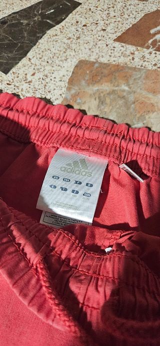 Dos pantalones deportivos Adidas negro y rojo.