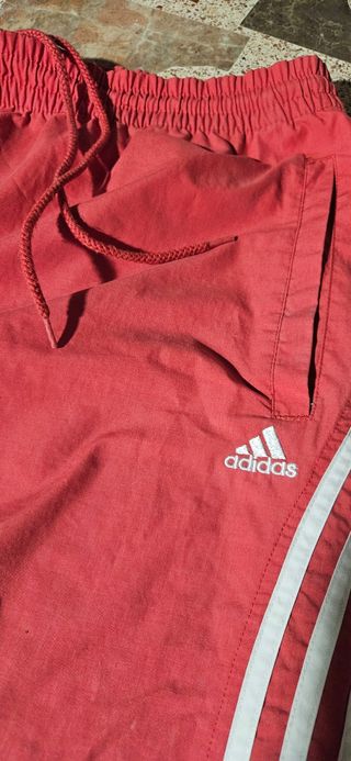 Dos pantalones deportivos Adidas negro y rojo.