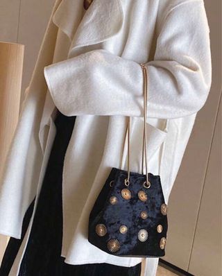 Bolso de terciopelo negro con adornos dorados
