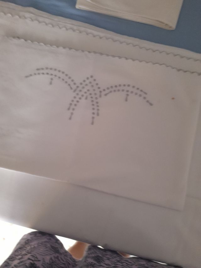 Juego de cama bordado.