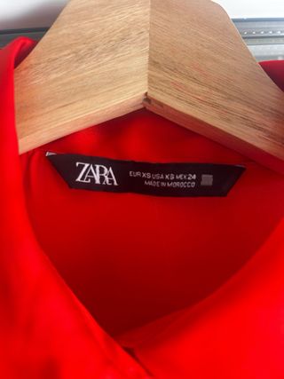 Camisa de satén roja
con un enganchón