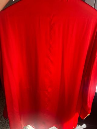 Camisa de satén roja
con un enganchón