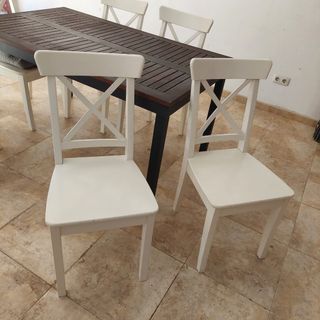 Mesa de madera marrón con 6 sillas blancas