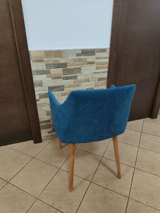 Silla azul de tela con patas de madera