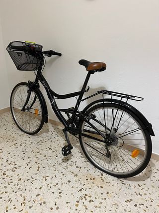 bicicleta de paseo negra con cesta y portabultos