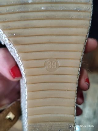 Sandalias marrones con cuña y tachuelas.