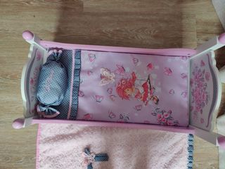 Cama de muñeca rosa con manta