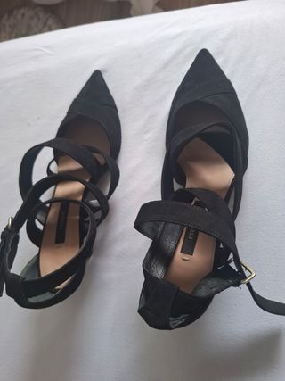 Zapatos de tacón negros con tiras .