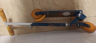 Patinete azul con ruedas naranjas