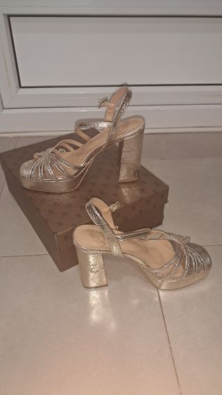 Sandalias doradas de tacón. El caballo