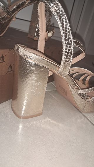 Sandalias doradas de tacón. El caballo