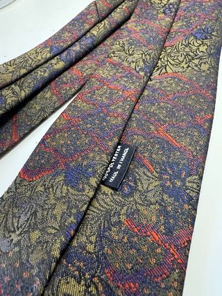 Corbata azul y dorada con flores rojas