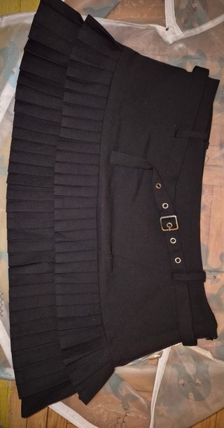 Falda corta plisada con cinturón.