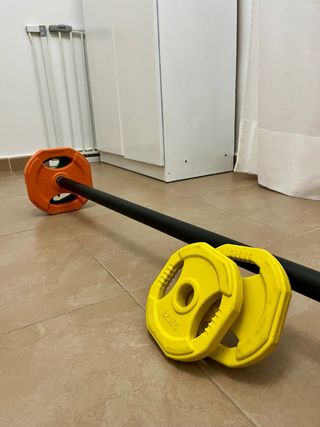 Barra de pesas con discos de colores