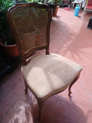 Silla antigua de madera con asiento tapizado.
