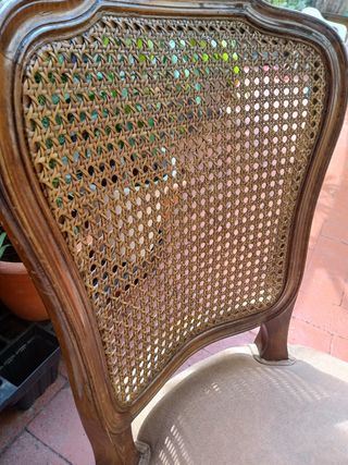 Silla antigua de madera con asiento tapizado.