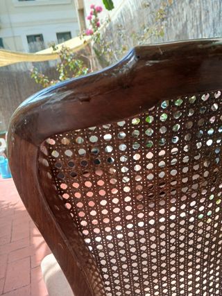 Silla antigua de madera con asiento tapizado.